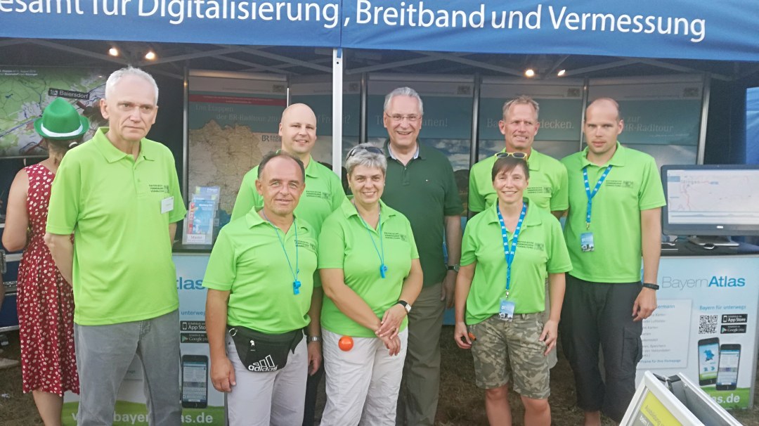 Staatsminister Joachim Herrmann und das BVV Team stehen vor dem Zelt der BVV und lächeln in die Kamera.